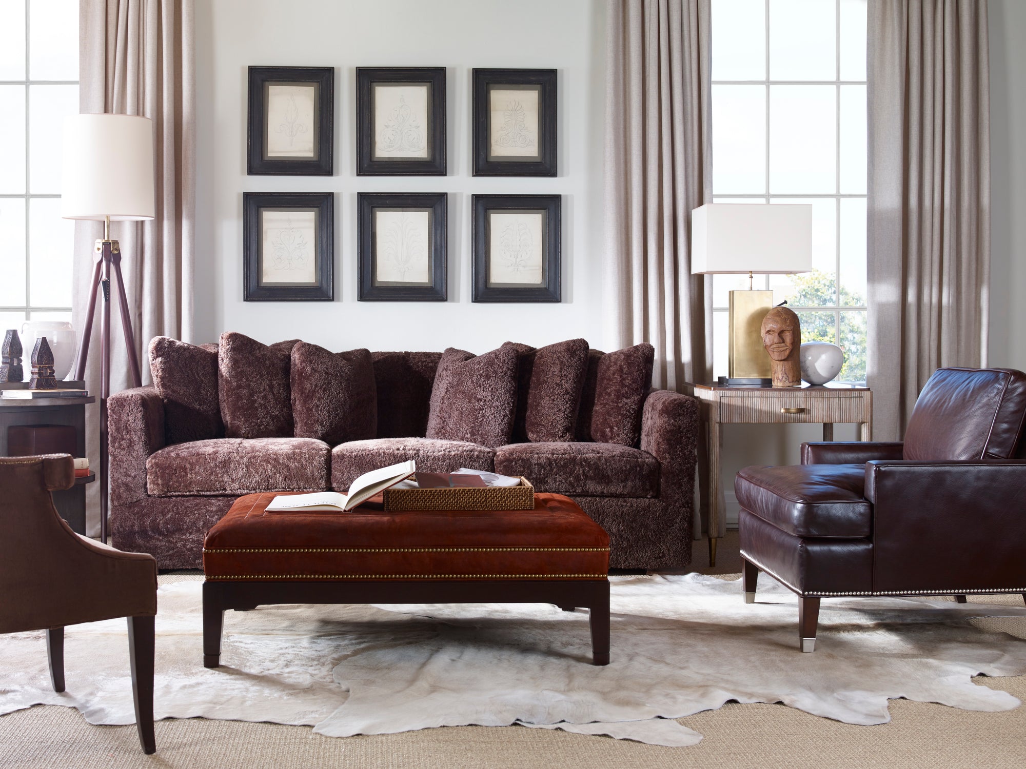 Living room with a brown sofa, ottoman, and armchair.