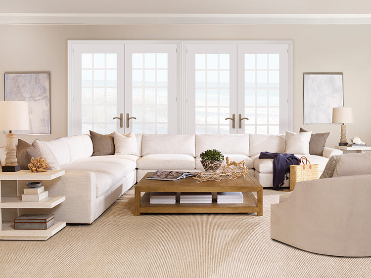 Modern living room with a white sectional sofa, wooden coffee table, and neutral decor.